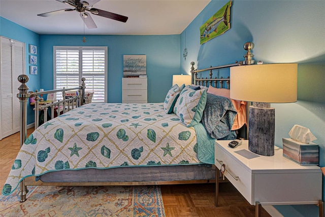 bedroom featuring parquet floors, ceiling fan, and a closet