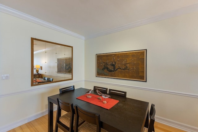 dining space with light wood-type flooring and crown molding