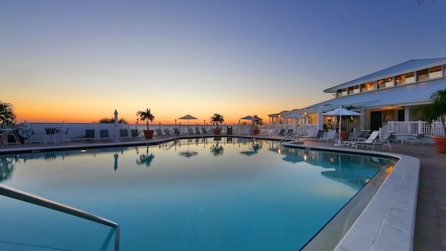 pool at dusk with a patio area