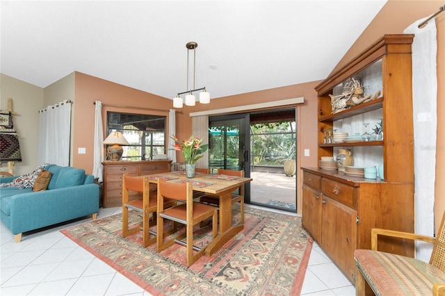 tiled dining space featuring lofted ceiling