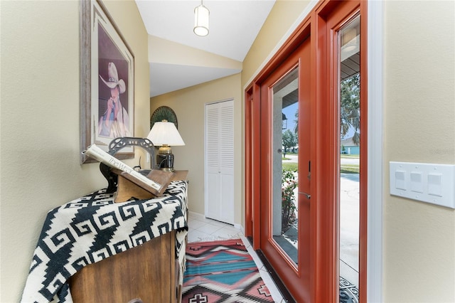 doorway to outside featuring lofted ceiling