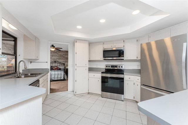 kitchen featuring a raised ceiling, appliances with stainless steel finishes, sink, and light tile patterned floors