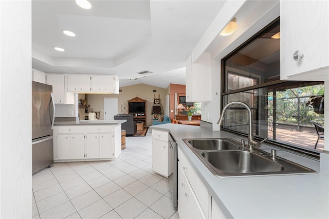 kitchen with appliances with stainless steel finishes, sink, white cabinets, and kitchen peninsula