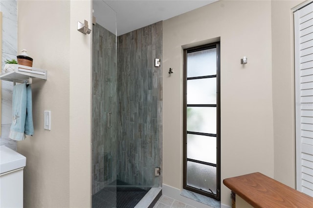 bathroom featuring toilet, tile patterned flooring, and a shower with door