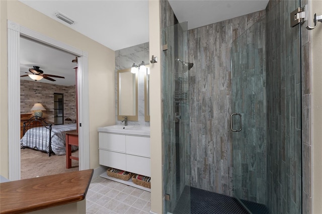 bathroom with ceiling fan, vanity, a shower with door, and a wood stove