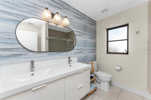 bathroom with tile patterned flooring, vanity, toilet, and walk in shower