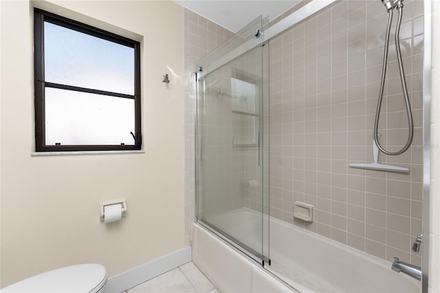 bathroom with tile patterned floors, shower / bath combination with glass door, and toilet