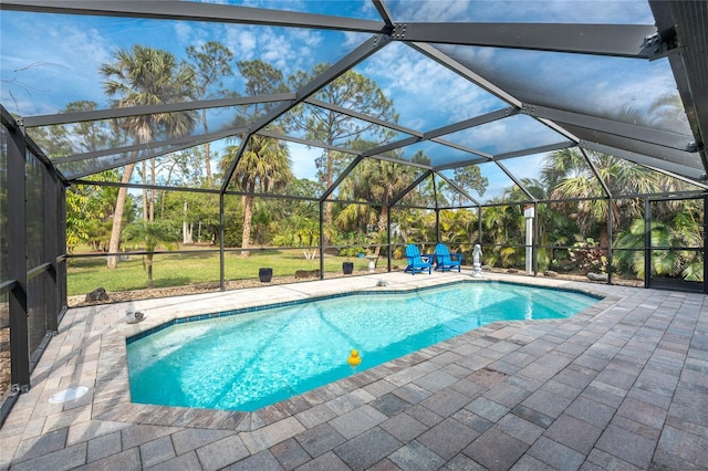 view of pool with a yard, a patio area, and glass enclosure