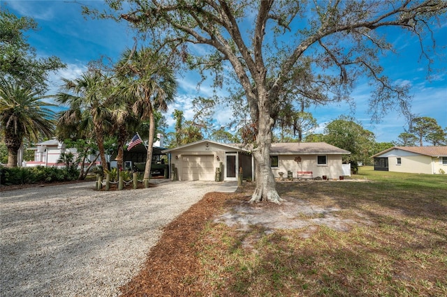 single story home with a garage and a front lawn