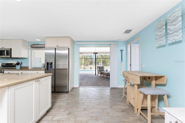 kitchen featuring stainless steel appliances and white cabinets