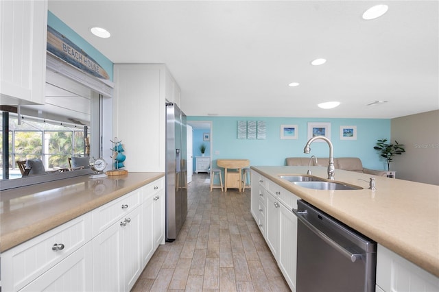 kitchen featuring stainless steel appliances, sink, and white cabinets