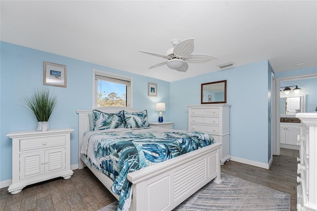 bedroom with ensuite bath, dark wood-type flooring, and ceiling fan