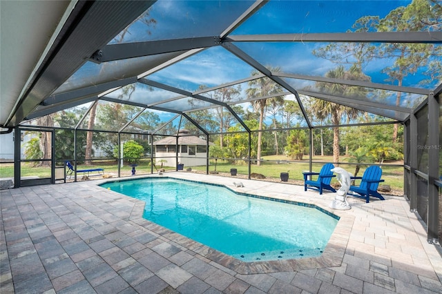 view of pool featuring an outbuilding, a lanai, a patio area, and a lawn