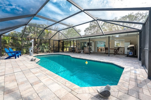 view of pool with a patio area and glass enclosure