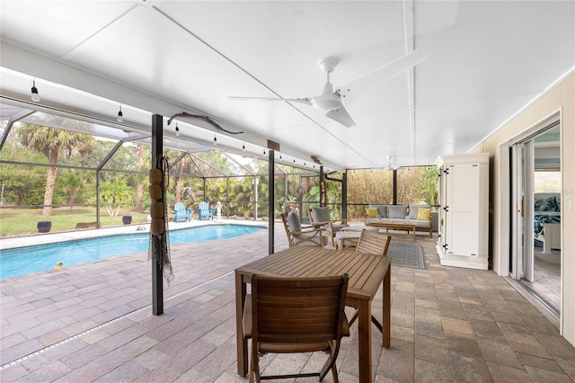 view of swimming pool featuring ceiling fan, an outdoor living space, a patio, and glass enclosure