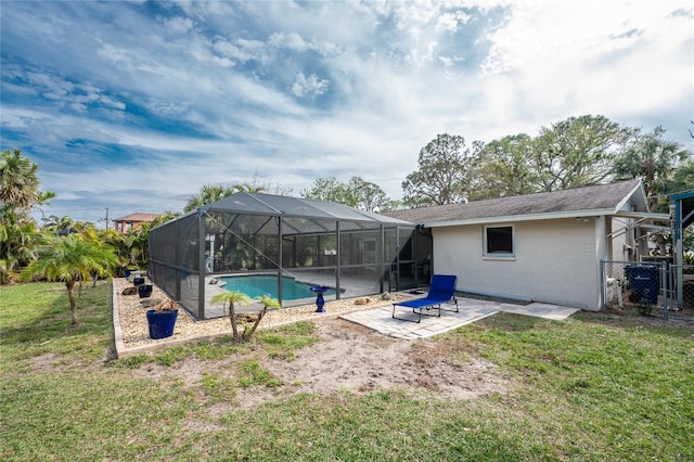 view of pool featuring a patio, glass enclosure, and a lawn