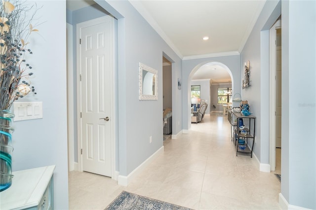 corridor with ornamental molding and light tile patterned flooring