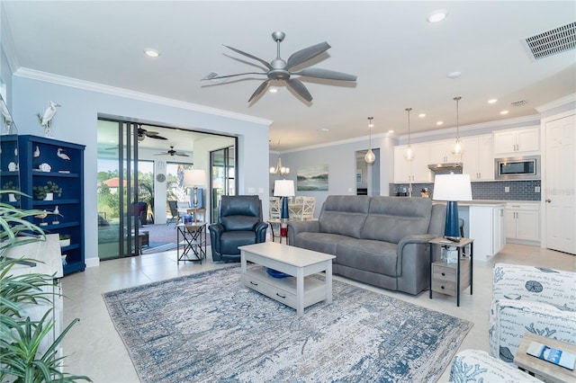 living room with crown molding, ceiling fan with notable chandelier, and light tile patterned flooring