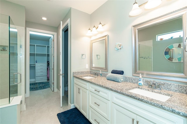 bathroom with vanity, a shower with shower door, and tile patterned floors