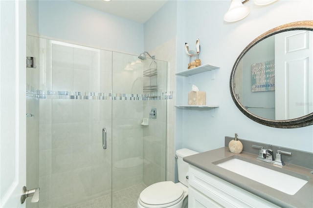 bathroom featuring vanity, toilet, and a shower with shower door