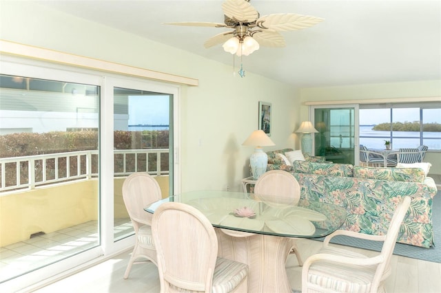 dining space featuring ceiling fan and a water view