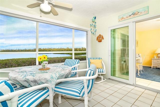 sunroom with a water view and ceiling fan