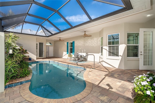 view of swimming pool with glass enclosure, ceiling fan, and a patio area