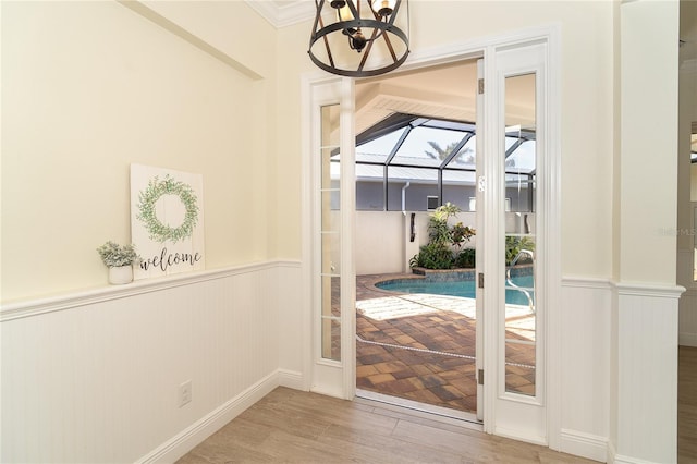 doorway to outside featuring hardwood / wood-style flooring and crown molding