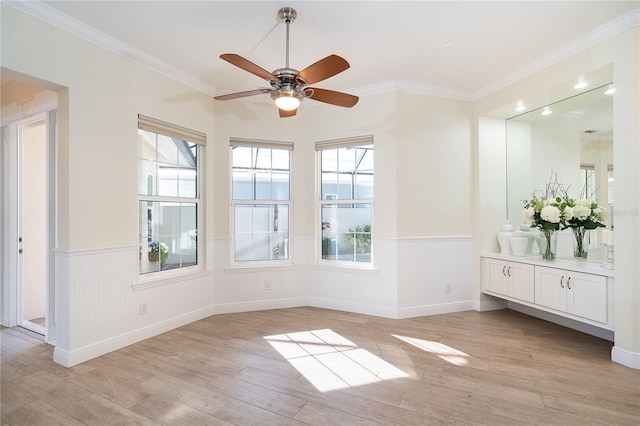 spare room featuring crown molding, light hardwood / wood-style floors, and ceiling fan