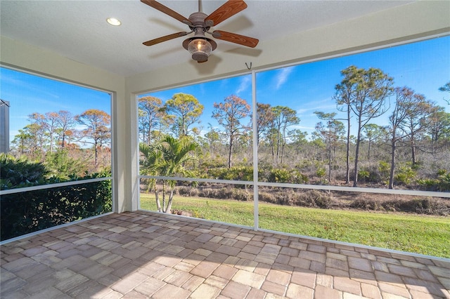 unfurnished sunroom featuring ceiling fan