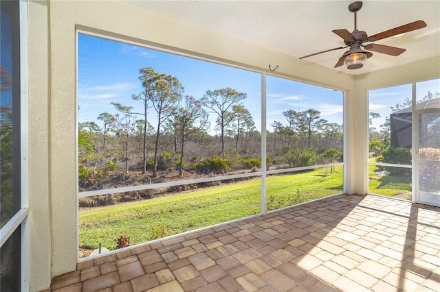 unfurnished sunroom with ceiling fan