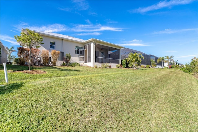 back of property featuring a yard and glass enclosure