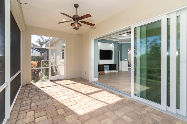 unfurnished sunroom with ceiling fan