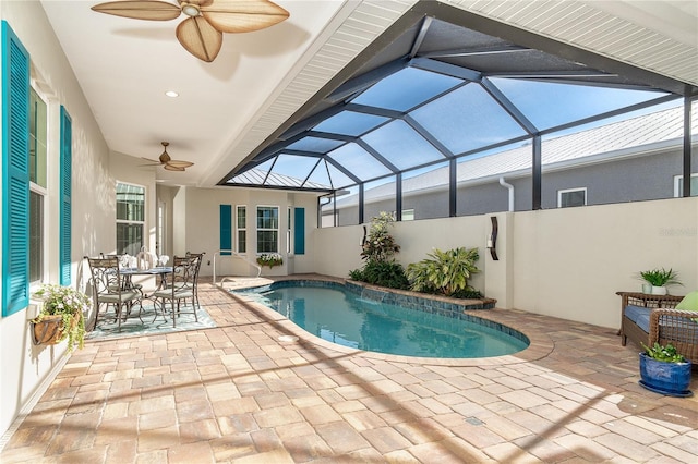 view of swimming pool with a patio area, ceiling fan, and glass enclosure