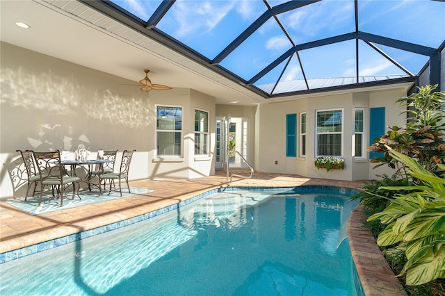 view of pool featuring ceiling fan, glass enclosure, and a patio