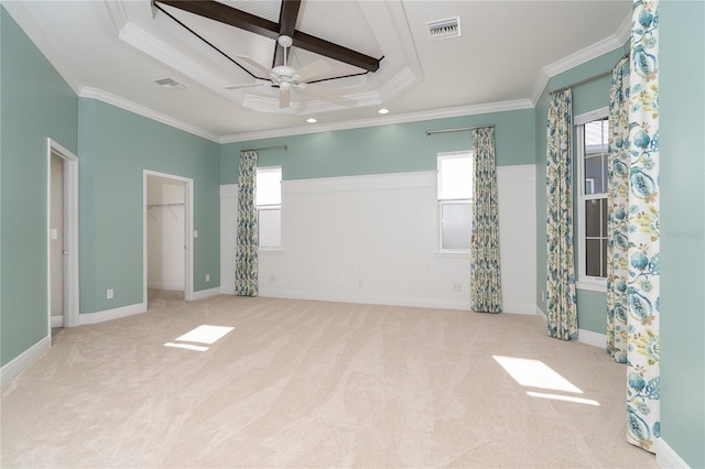 unfurnished bedroom featuring light colored carpet, ornamental molding, a raised ceiling, and multiple windows