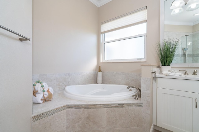 bathroom with crown molding, vanity, and tiled tub