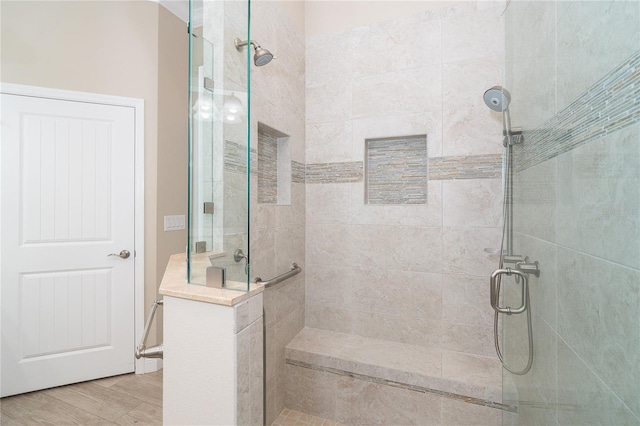 bathroom with hardwood / wood-style flooring and a shower with door