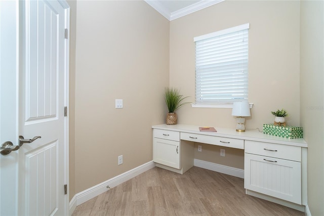 unfurnished office with crown molding, built in desk, and light wood-type flooring