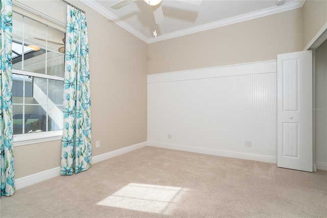 carpeted empty room featuring crown molding and ceiling fan