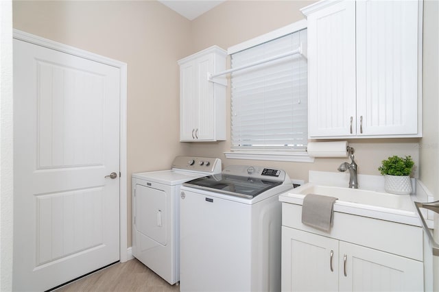 laundry room with cabinets, independent washer and dryer, and sink