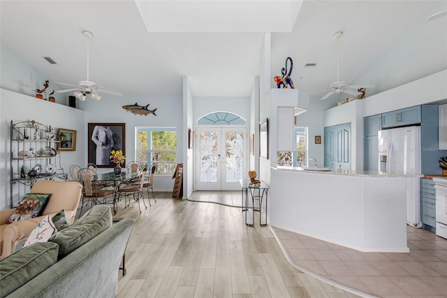 interior space with high vaulted ceiling, ceiling fan, and french doors