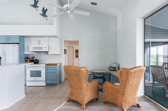 kitchen featuring white appliances, white cabinetry, blue cabinets, high vaulted ceiling, and ceiling fan