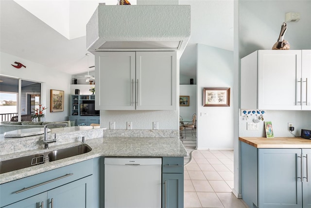 kitchen featuring lofted ceiling, dishwasher, sink, kitchen peninsula, and butcher block countertops