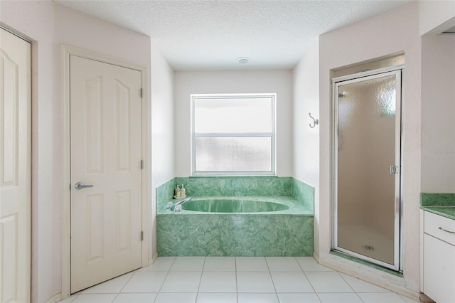 bathroom featuring a textured ceiling, vanity, and shower with separate bathtub