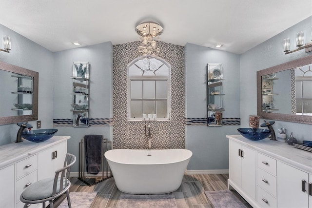 bathroom with lofted ceiling, a bathing tub, and vanity