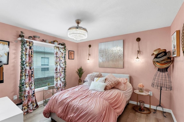 bedroom featuring a chandelier and light hardwood / wood-style flooring