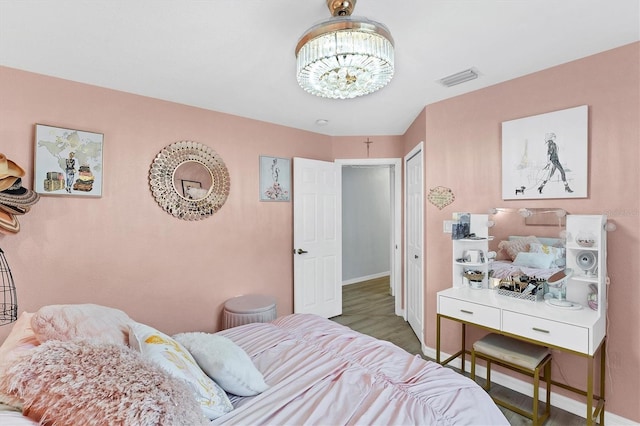 bedroom featuring hardwood / wood-style flooring and an inviting chandelier