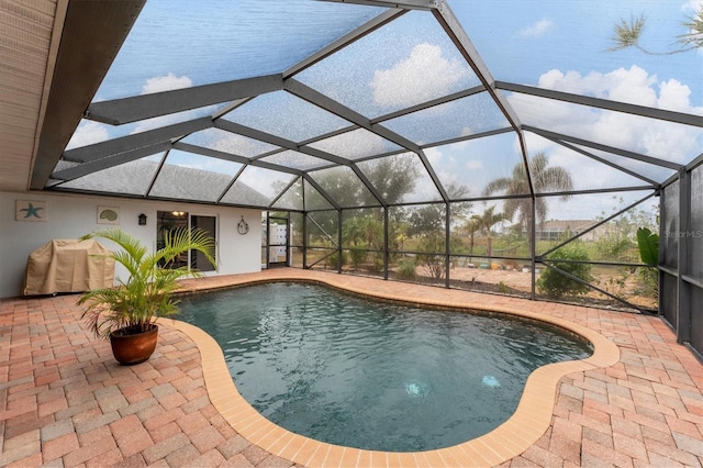 view of swimming pool with a patio area and glass enclosure