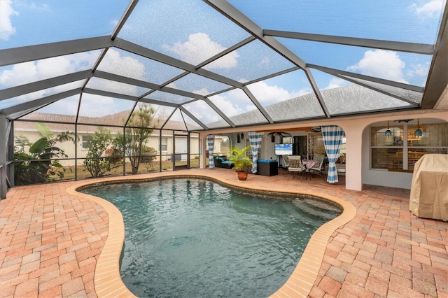 view of pool with ceiling fan, an outdoor hangout area, a patio area, and glass enclosure